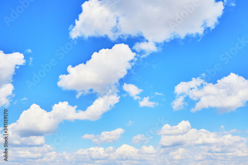 Background  Cumulus clouds in a bright blue sky.