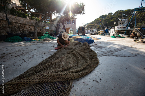 fisherman repairs the nets