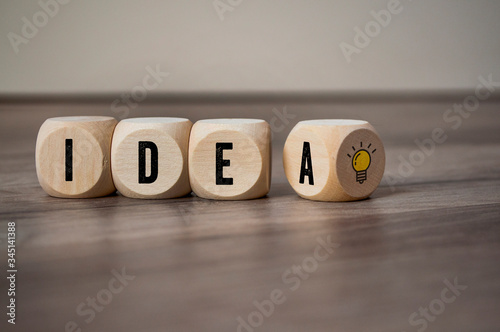 Cubes and dice with light bulb icon and idea - plan do check act on wooden background