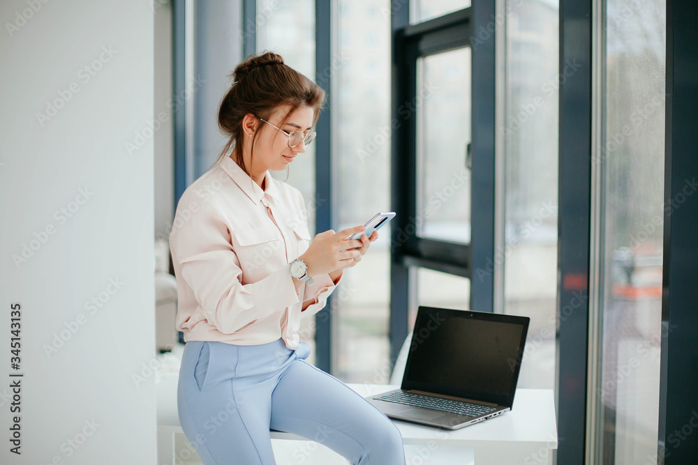 © Kateryna Ivaskevych - portrait of young businesswoman working on laptop in the office. © Kateryna Ivaskevych - portrait of young businesswoman working on laptop in the office.