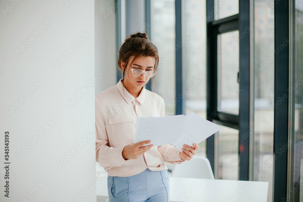 portrait of young businesswoman working  in the office and 
looks at the documents.