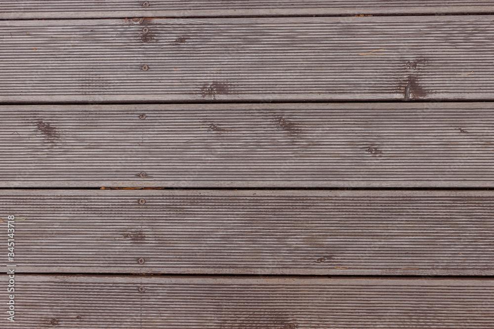 Old exterior wooden decking or flooring on the terrace.Background of a wenge-colored terrace Board with horizontal stripes. Design backgrounds textures construction.Terrace board.hardwood floor Old exterior wooden decking or flooring on the terrace.Background of a wenge-colored terrace Board with horizontal stripes. Design backgrounds textures construction.Terrace board.hardwood floor