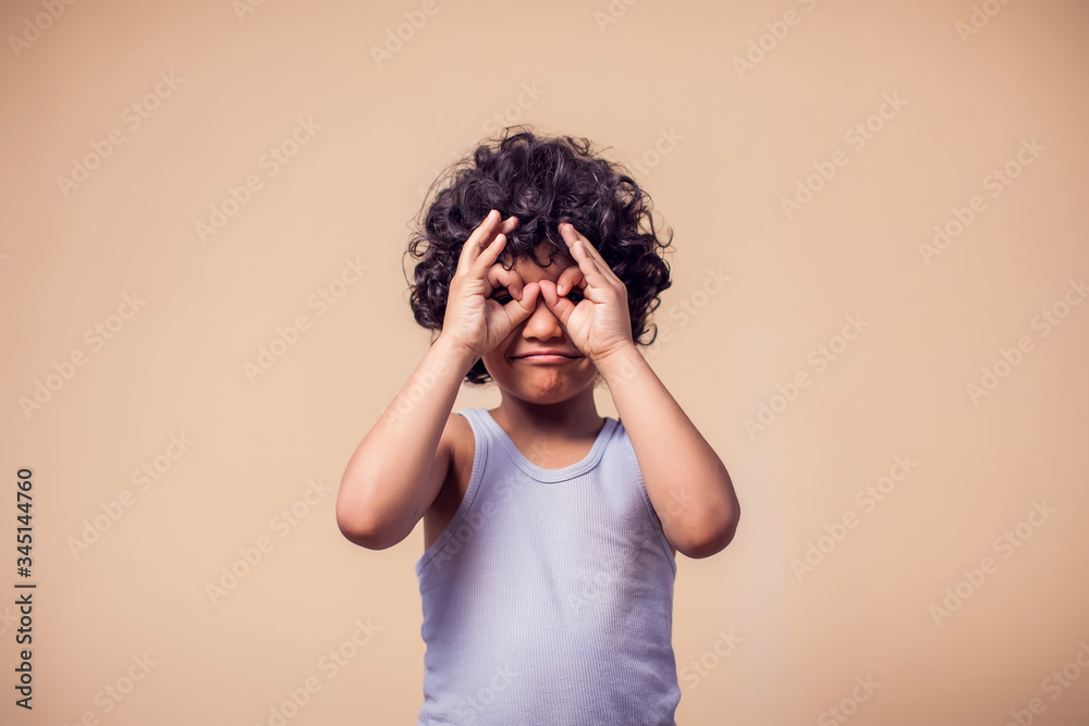 A portrait of smiling kid boy showing binocular gesture. Children and emotions concept A portrait of smiling kid boy showing binocular gesture. Children and emotions concept