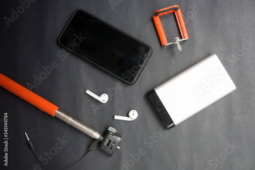 Tableau sur toile telefono negro, palo selfie rojo, auriculares inalámbricos y bateria externa, ac