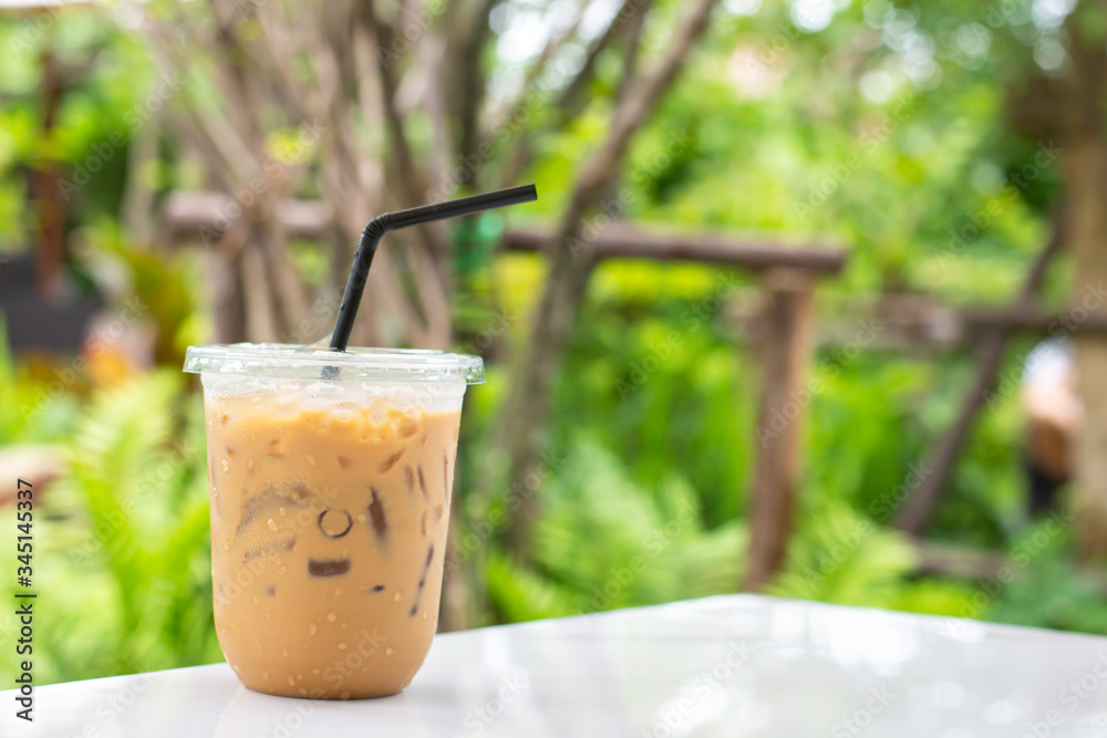 Glass of cold espresso coffee on table Background blurry views tree. Glass of cold espresso coffee on table Background blurry views tree.