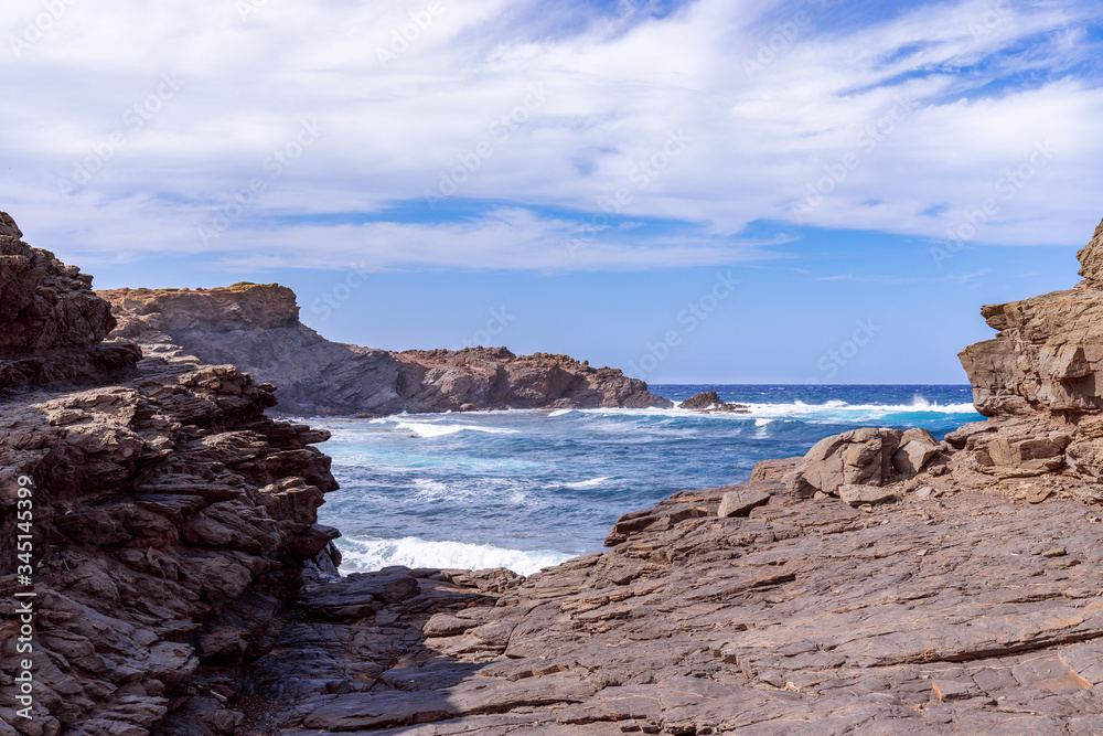 Beautiful view of a rocky bay with waves on the sea on the island of Menorca, Balearic islands, Spain Beautiful view of a rocky bay with waves on the sea on the island of Menorca, Balearic islands, Spain