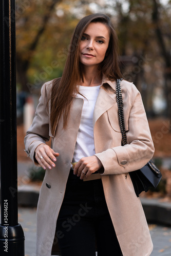 Obraz na płótnie Outdoor fashion portrait of stylish young woman having fun, emotional face , laughing, Urban city street style wearing dark casual trousers, white sweater,creamy coat. and sunglasses Fashion concept. w salonie