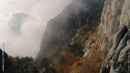 The canyon of the Crimea is a popular place, fog, rocks in the clouds, teeth of stone, drone flight over the clouds, smooth flight at the height of a bird's flight, the black sea