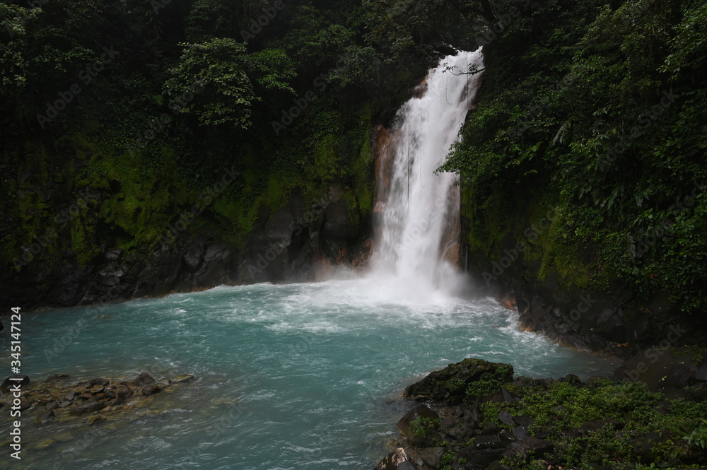 Fototapeta premium Costa Rica Waterfall in Summer into Blue Water