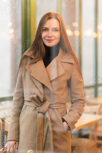 Obraz na płótnie Outdoor fashion portrait of stylish young woman having fun, emotional face , laughing, Urban city street style wearing dark casual trousers, white sweater,creamy coat. and sunglasses Fashion concept. w salonie