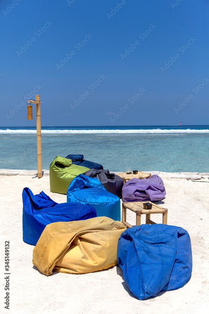 Colored sunbed and Umbrella under the tree in ocean view of Indonesia, Gili Trawangan island. 
