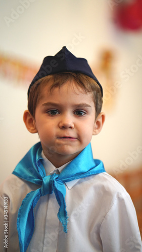 Portrait of cute boy in white shirt and blue tie in kindergarten