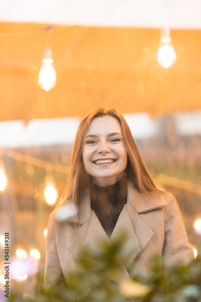 Outdoor fashion portrait of stylish young woman having fun, emotional face , laughing, Urban city street style wearing dark casual trousers, white sweater,creamy coat. and sunglasses Fashion concept.