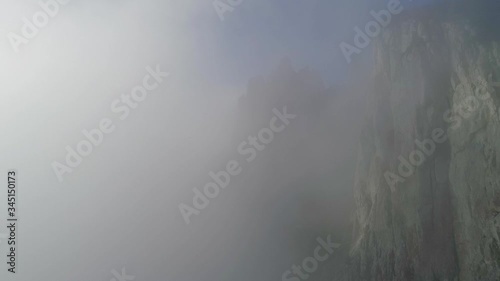 The canyon of the Crimea is a popular place, fog, rocks in the clouds, teeth of stone, drone flight over the clouds, smooth flight at the height of a bird's flight, the black sea