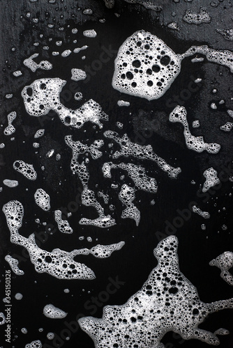 abstract detail of soap bubbles over dark bathroom tile photo