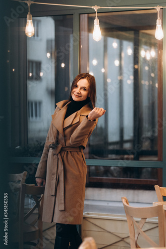 Obraz na płótnie Outdoor fashion portrait of stylish young woman having fun, emotional face , laughing, Urban city street style wearing dark casual trousers, white sweater,creamy coat. and sunglasses Fashion concept. w salonie