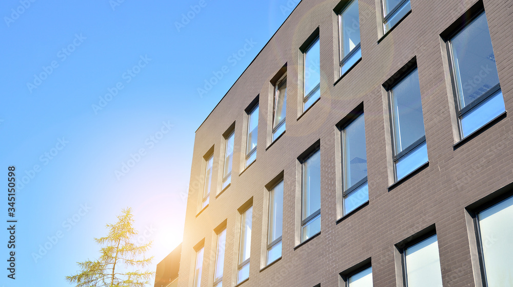 Glass building with blue sky background. Modern office building detail, glass surface clouds reflected in windows of modern office building.