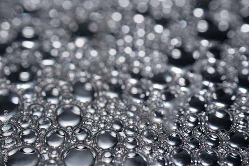 An image of background with water droplets on mirror in black and white tone with blur bokeh behind