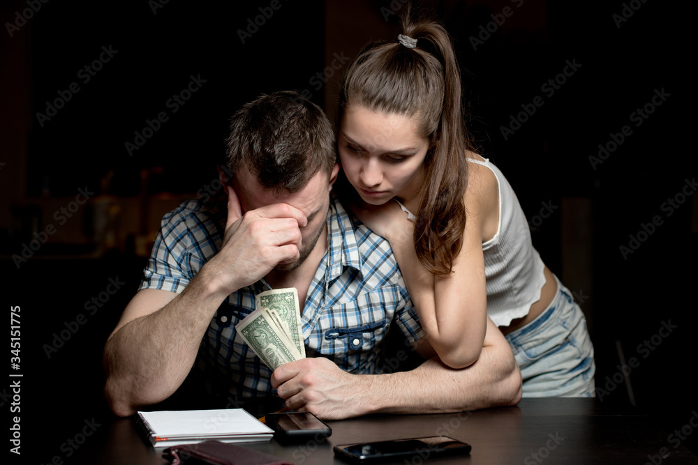 man holds money and is upset. wife supports him morally. The financial crisis man holds money and is upset. wife supports him morally. The financial crisis