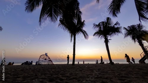 4k Time lapse colorful sunset on tropical beach with silhouette palm tree, sea and beautiful clouds on horizon