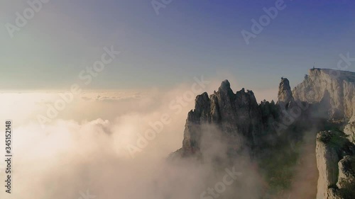 The canyon of the Crimea is a popular place, fog, rocks in the clouds, teeth of stone, drone flight over the clouds, smooth flight at the height of a bird's flight, the black sea