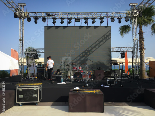 Open air show stage set up with led screen, sound and light system. Back line with drums.