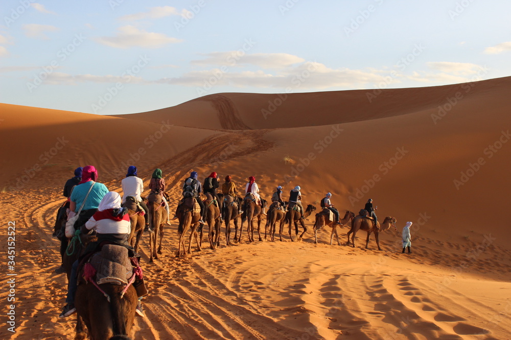 camel riding in sahara desert