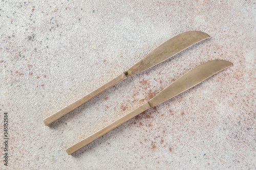 Two old bronze knives on concrete background. photo