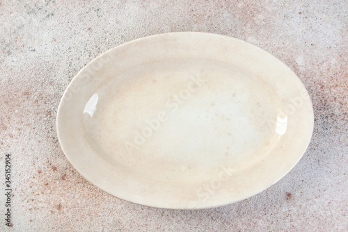 Antique porcelain oval plate on concrete