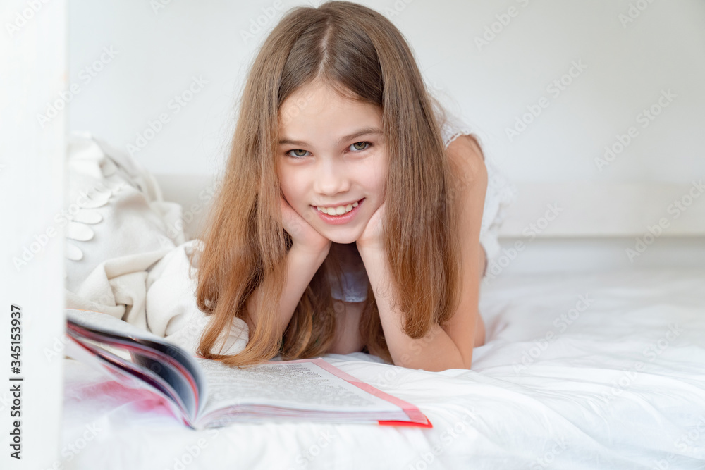 school concept. little girl with book lying on bed school concept. little girl with book lying on bed