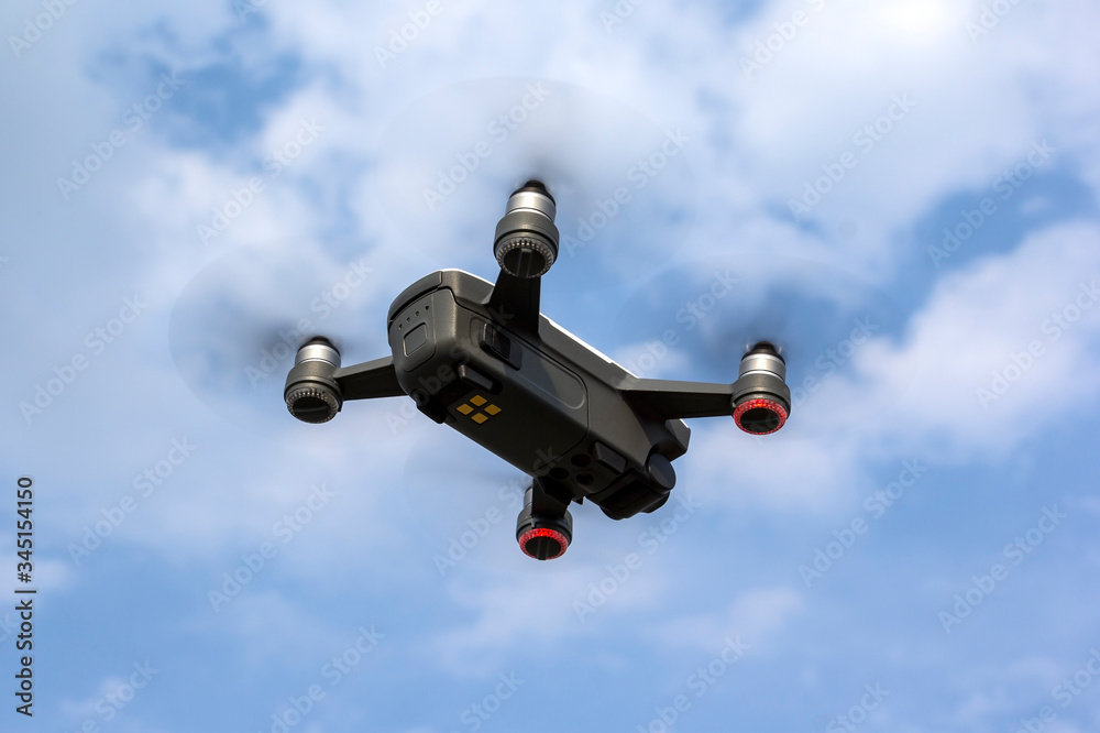 A small drone flies in the sky.