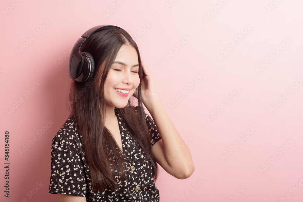 Music lover woman is enjoying with headset on pink background Music lover woman is enjoying with headset on pink background