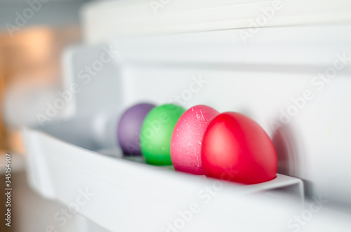 Easter eggs of different colors are in the refrigerator door