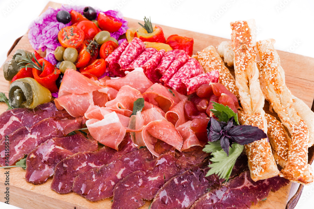 Assorted meat on a wooden board on a white background. Horizontal photo Assorted meat on a wooden board on a white background. Horizontal photo