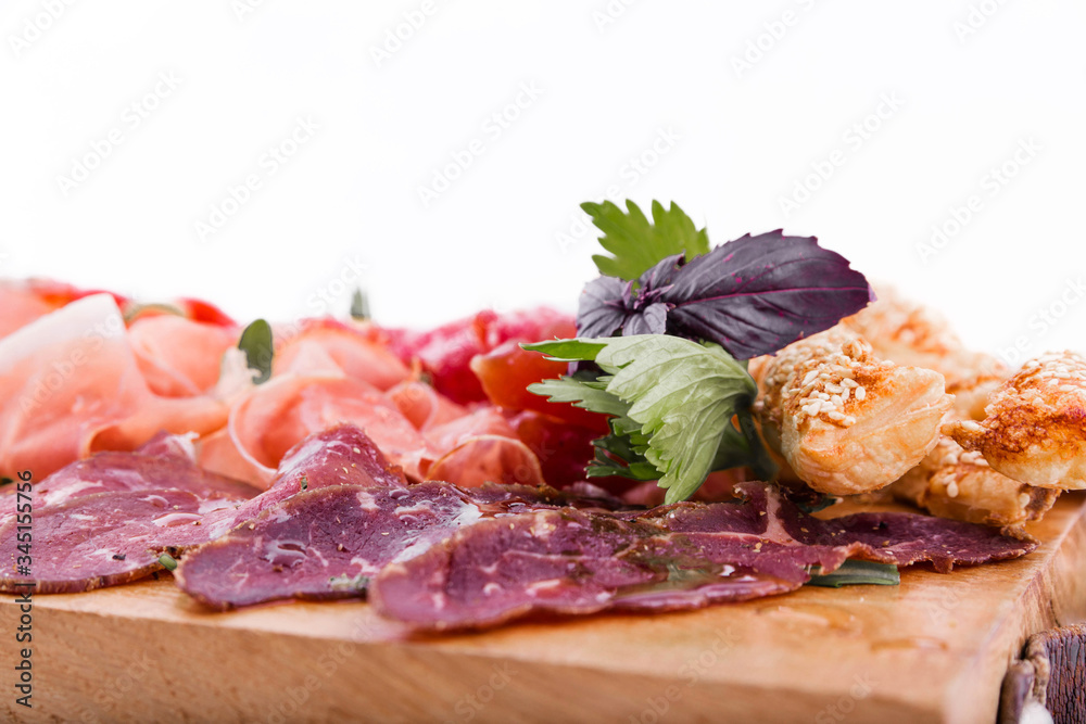 Assorted meat on a wooden board on a white background. Horizontal photo