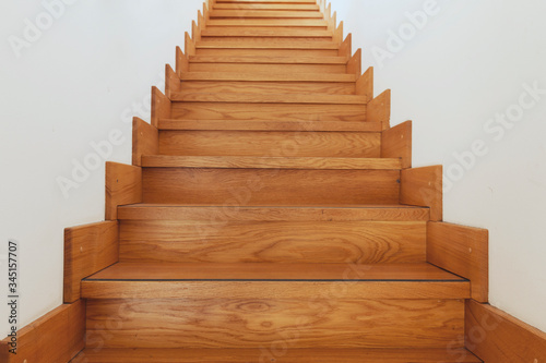Wooden staircase and white walls bottom view