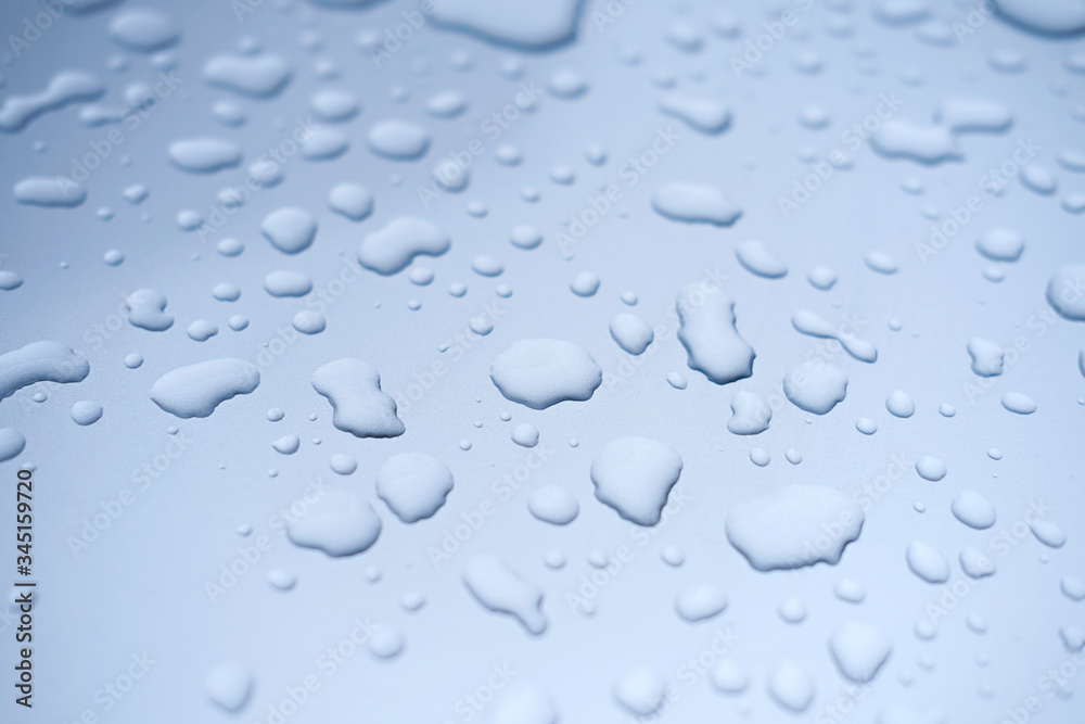 water drops on blue background. close up view. rain drops on a car. car paint protection concept. paint protection film for cars.