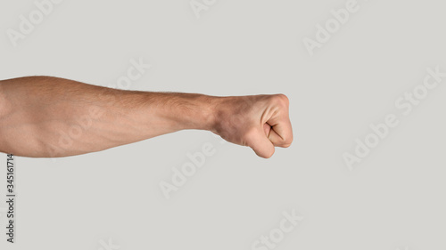 Картината върху платно Millennial man clenching fist on light grey background, close up