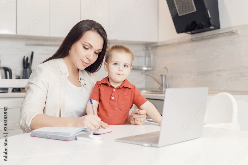 Businesswoman mother woman with small child son working online computer home office Businesswoman mother woman with small child son working online computer home office