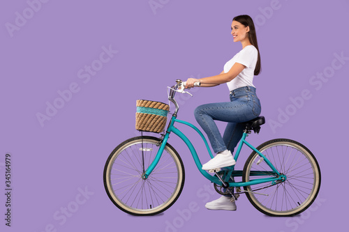 Beautiful woman riding her bike at studio, isolated © Prostock-studio