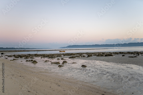 Paisaje de una playa durante el amanecer con un barco aislado en medio del mar. Havelock  Islas Andaman   India.
