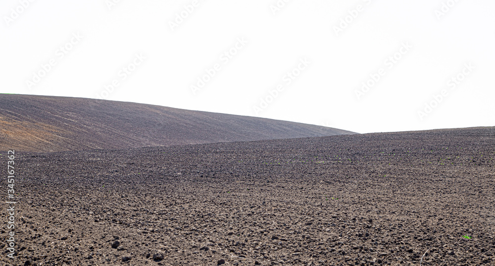 Beautiful black earth fields. Agricultural rural landscape, colorful hills. Plowed dark land.