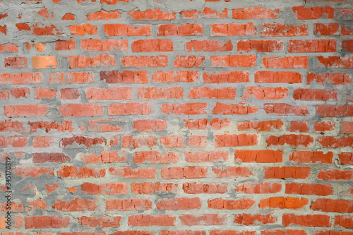 Red brick wall background. Wall of brick and cement close-up. The texture of the new brick wall is orange.