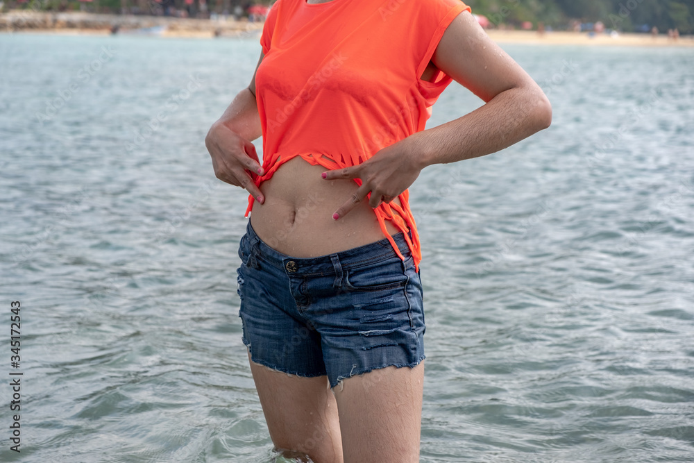 Young thai girl shows her sexy belly at the beach Stock Photo | Adobe Stock