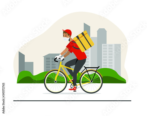 A man on a bicycle rides around the city. A courier in a mask, gloves and boxing, box, cargo. 