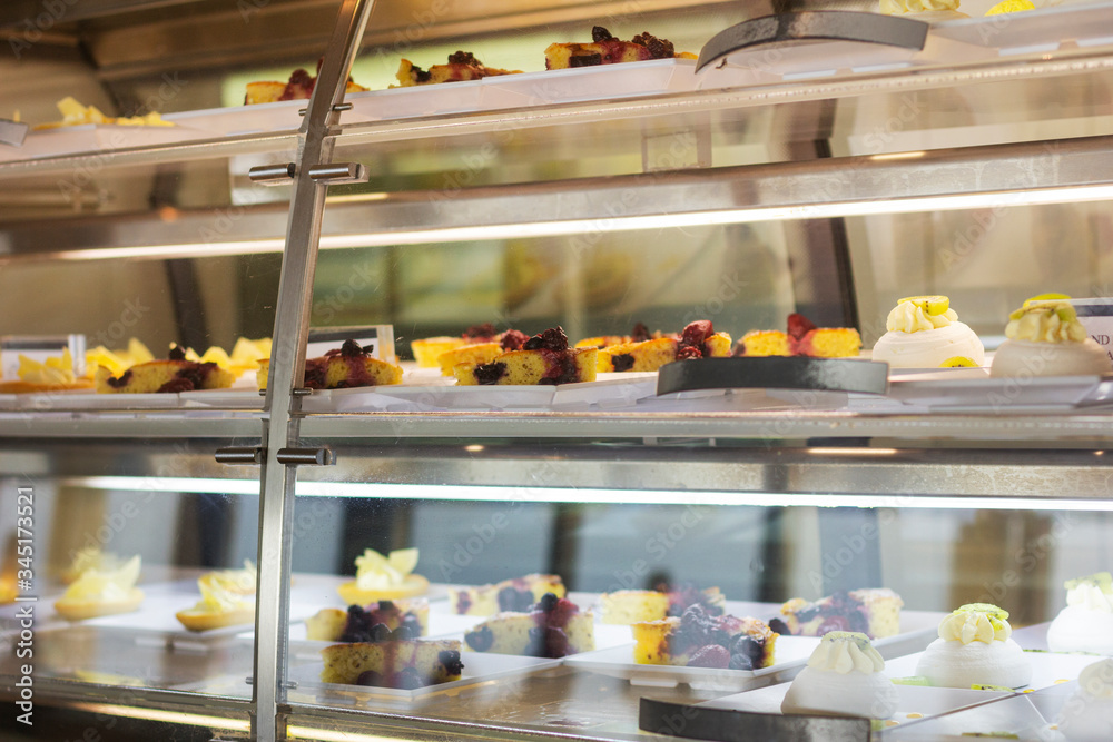 Cakes under the glass. Sweets in the dining room. Sweets at the hotel. Bakery products.
