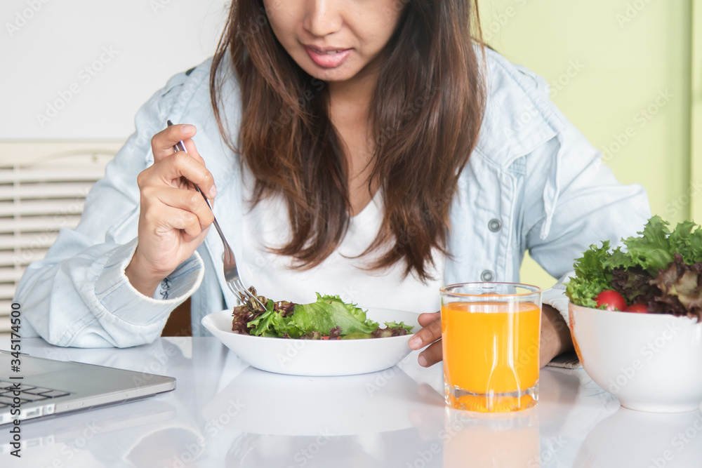 Eating healthy breakfast concept. woman holding dish of salad with variety vegetables and glass of orange juice on the floor in the morning at home. Eating healthy breakfast concept. woman holding dish of salad with variety vegetables and glass of orange juice on the floor in the morning at home.