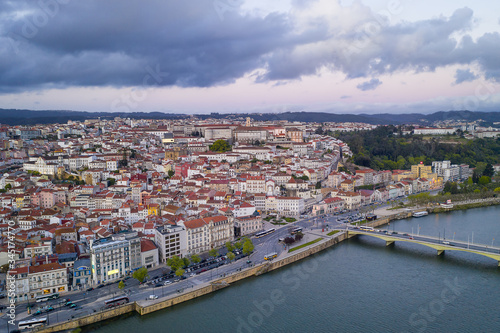 Coimbra drone aerial city view at sunset with Mondego river and beautiful historic buildings, in Portugal