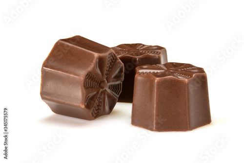 Chocolate pralines. Three dark chocolate bonbons with toffee fillings, macro close-up isolated on white background.