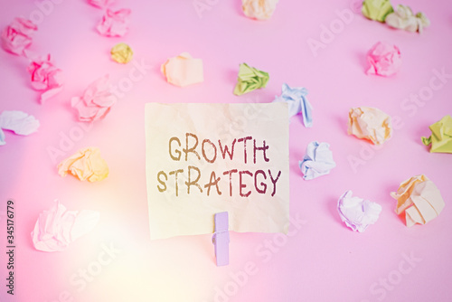 Conceptual hand writing showing Growth Strategy. Concept meaning Strategy aimed at winning larger market share in shortterm Colored crumpled papers empty reminder pink floor clothespin photo